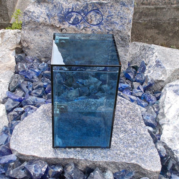 Zechmeister - Urnengrab mit bläulichem Granit und blauen Glassteinen und blauer Glaslaterne, am Grabstein ein graviertels Unendlichkeitszeichen - Wien Aspern